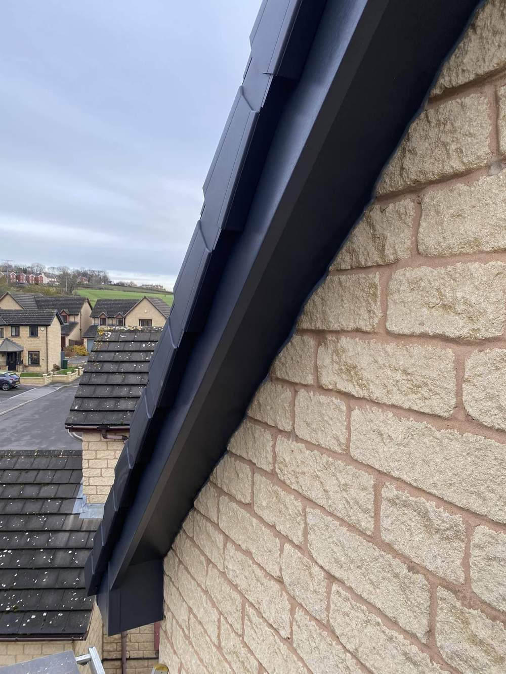 The same stone gable with a new anthracite bargeboard