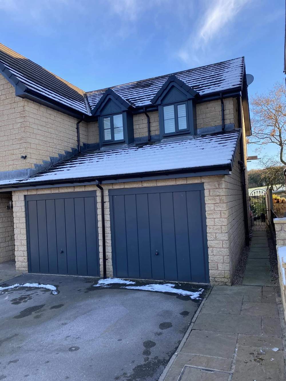 Stone house with a double garage and a new anthracite roofline