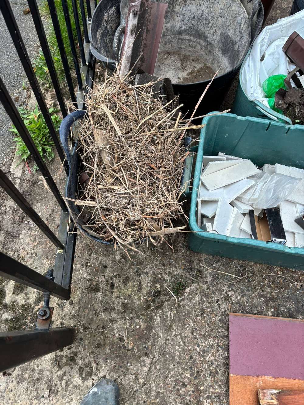 An old bird's nest removed from the eaves, bagged in a tub