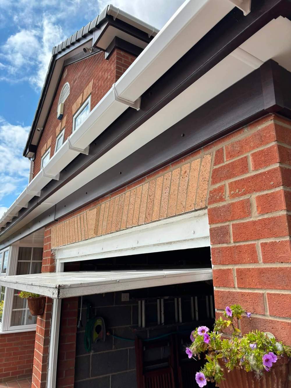 A finished white roofline on a red brick house, the scaffold gone