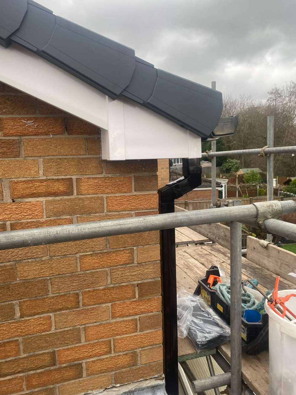 The boxed corner rebuilt in white with an anthracite verge and black downpipe