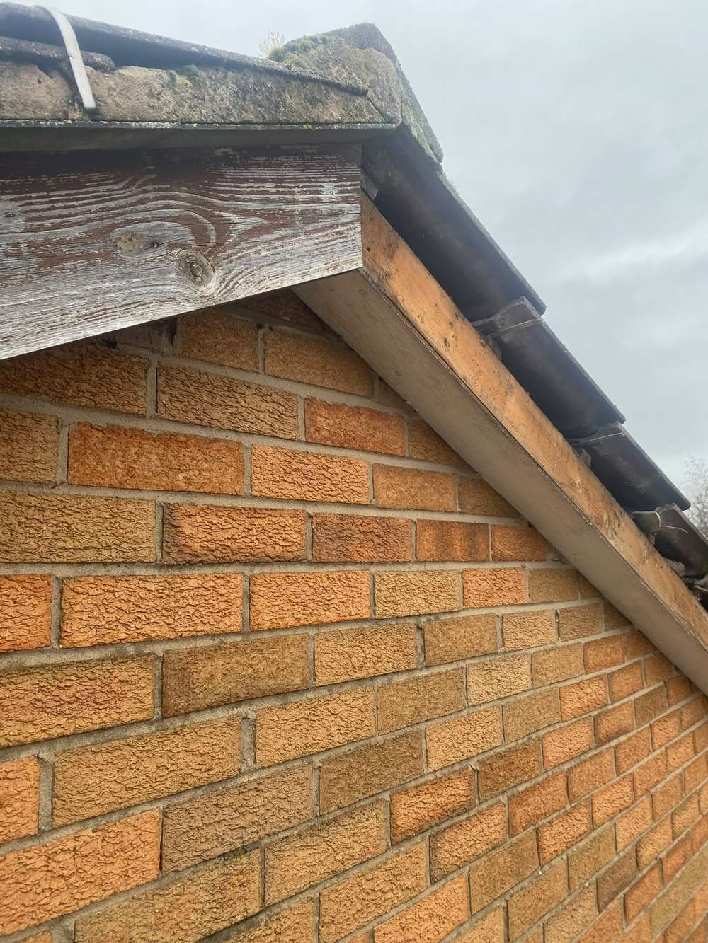 Gable apex with bare, weathered timber boards, before