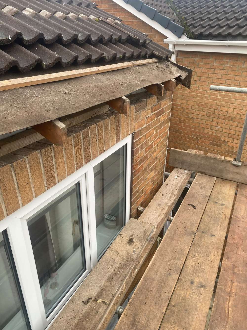 The same stretch of roof with the fascia removed and the rafter ends exposed
