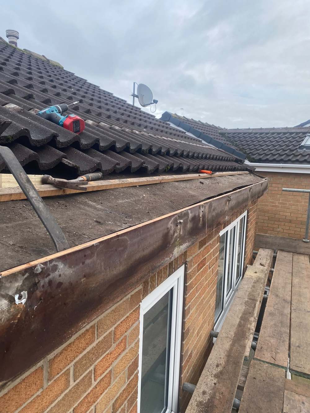 Brown painted timber fascia above a set of patio doors, the paint flaking