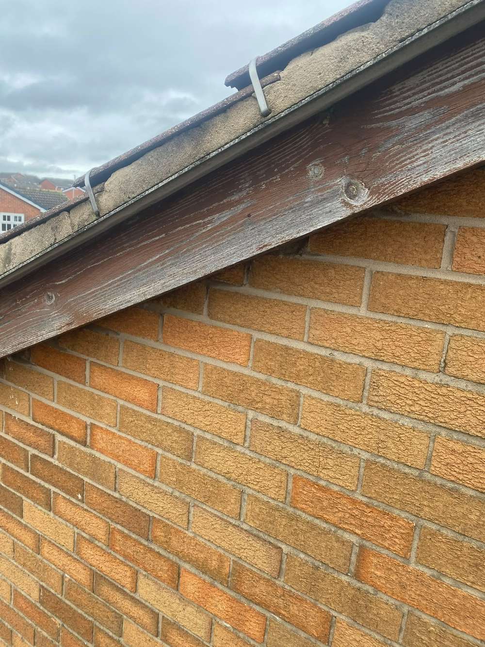 Weathered grey timber board with an old gutter bracket